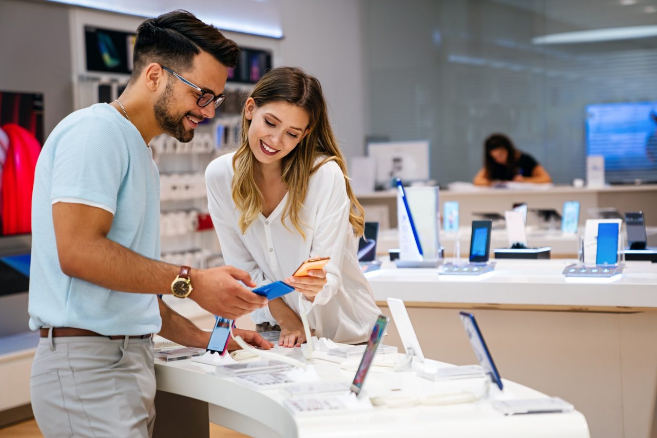 shopping a new digital device happy couple buying a smartphone in store.jpg